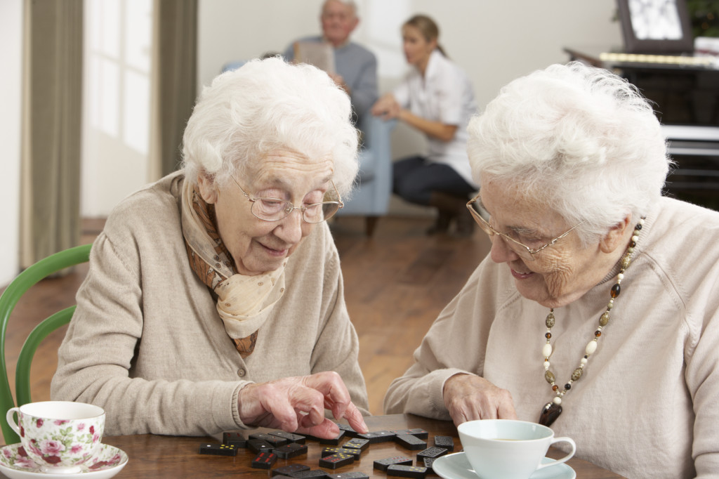 Two Senior Women Playing Dominoes At Day Care Centre